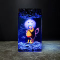 Handcrafted Coraline epoxy resin lamp with yellow raincoat figure, Button Moon, and blue LED lighting on wood base